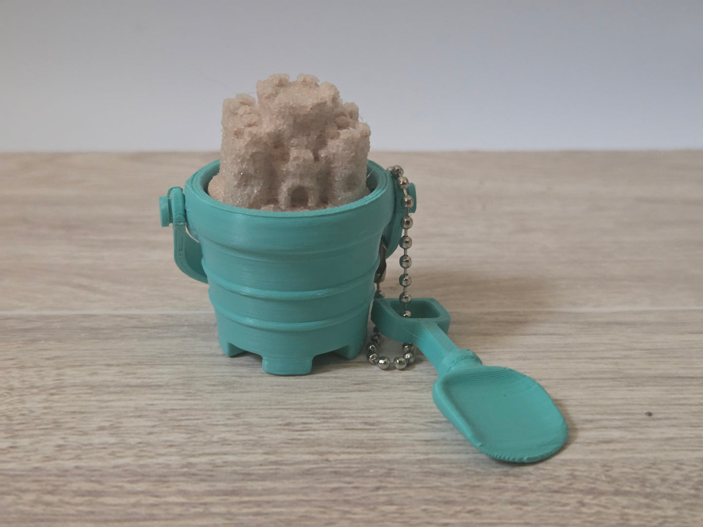 Teal sand bucket clicker